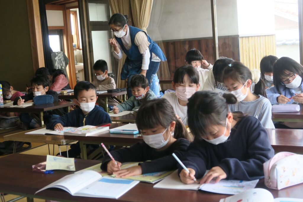 子どもたちを優しく指導する寺庭夫人の伊藤紀子さん（写真左上）